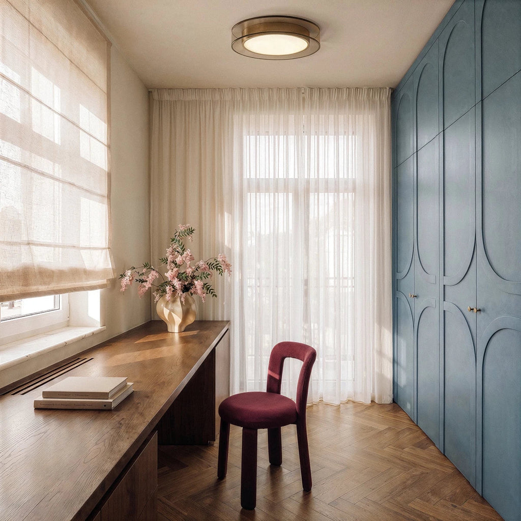 Clérachic halo ring ceiling light glowing above a desk nook with sheer curtains and a blue paneled wardrobe.