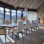 This Clérachic chandelier floats beneath a reclaimed-wood ceiling above a long dining table, with snowy mountain views behind.