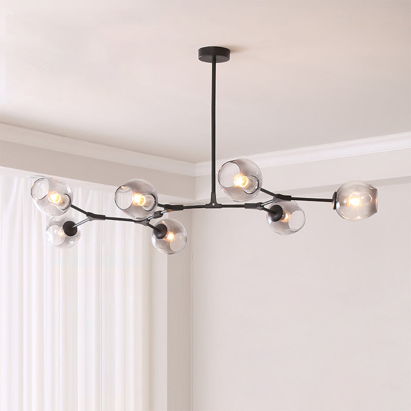 Black Clérachic chandelier with seven gradient grey glass globes spread across a pale ceiling beside white curtains.