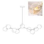 Outline of the 9-head Clérachic chandelier on white, paired with a small photo of a lit amber glass globe.