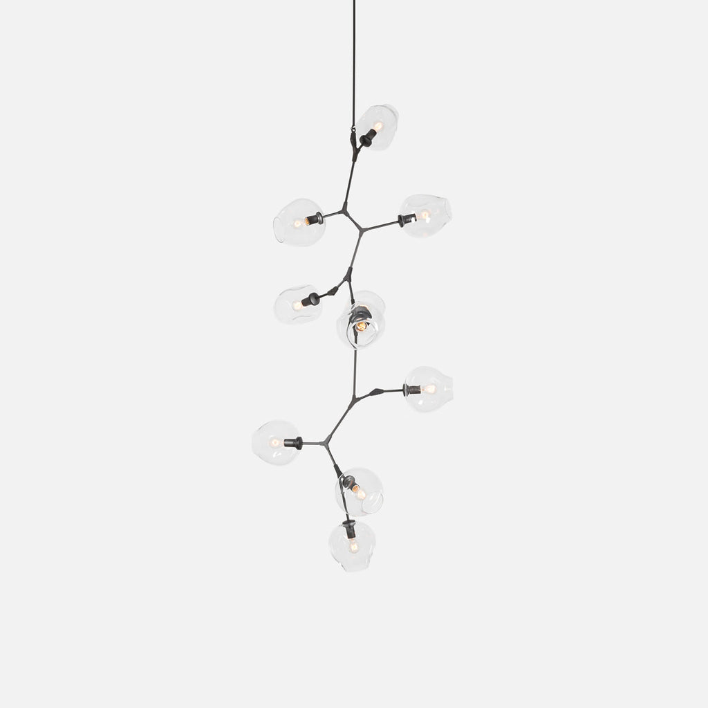 A Clérachic chandelier with clear globes and a dark frame, on a pale grey backdrop, hanging from a single fine rod.