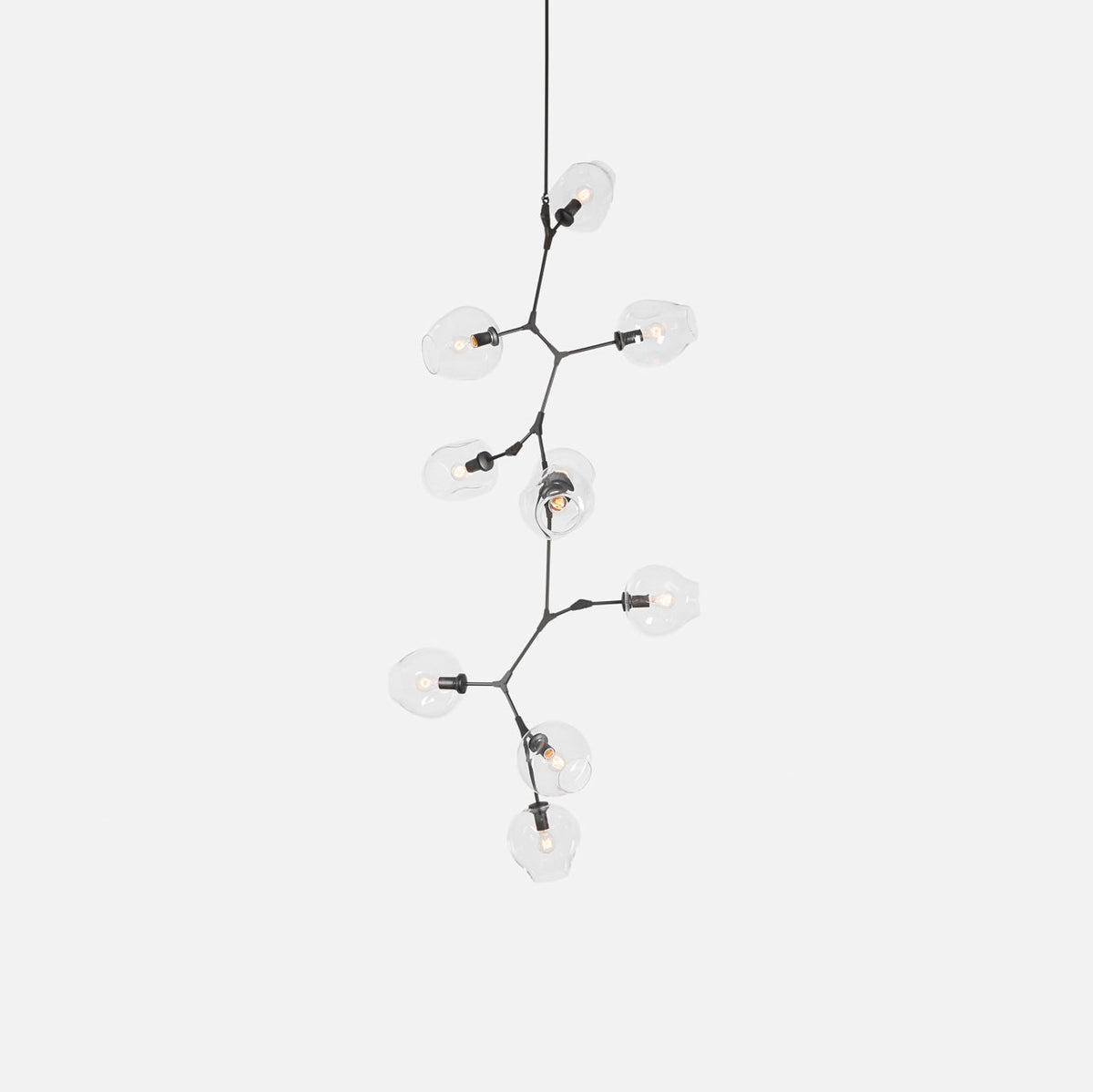 A Clérachic chandelier with clear globes and a dark frame, on a pale grey backdrop, hanging from a single fine rod.