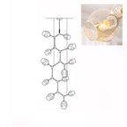 Inset close view of an amber glass globe lit from within, beside the line drawing of this Clérachic 12-head chandelier.