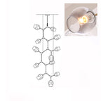 A lit, smoky grey glass globe in a close inset, next to the outline drawing of this 12-head Clérachic chandelier.