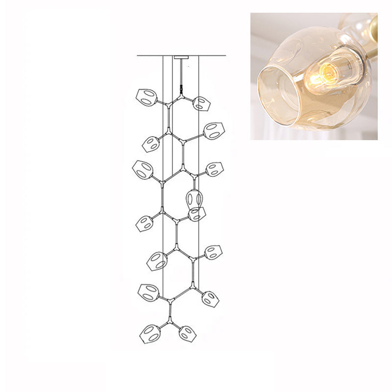 Inset close view of an amber glass globe lit from within, beside the line drawing of this Clérachic 15-head chandelier.
