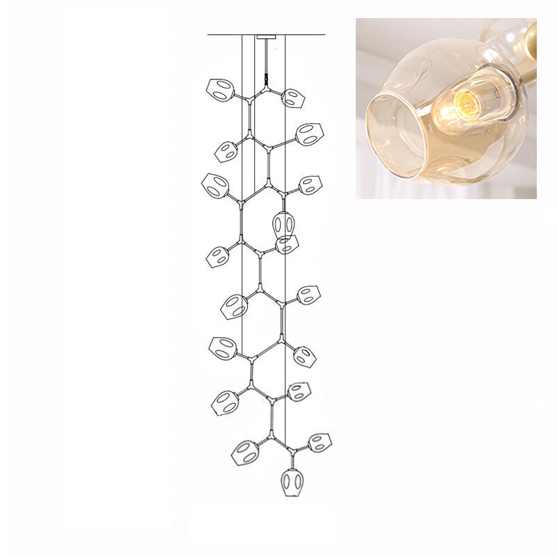Inset close view of an amber glass globe lit from within, beside the line drawing of this Clérachic 18-head chandelier.