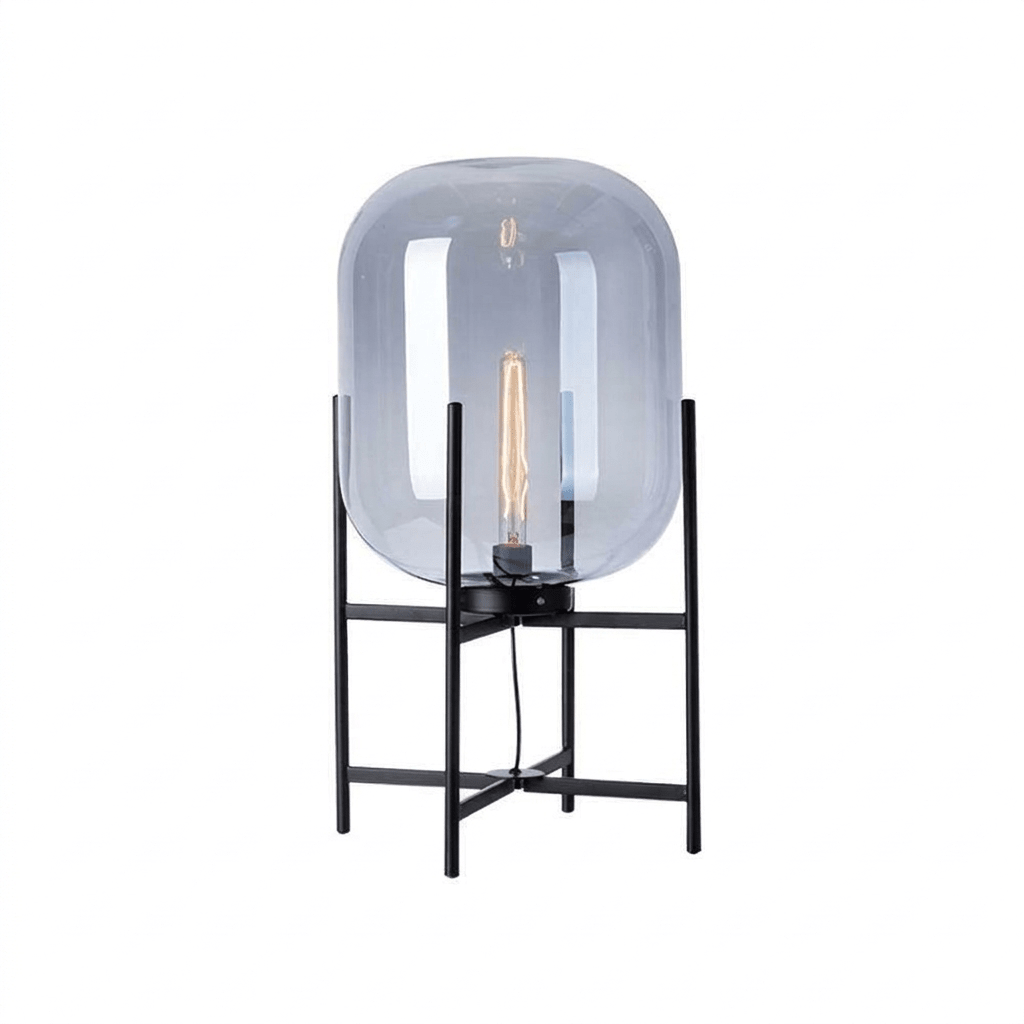 Blue-grey tinted glass shade with a tall filament bulb on a black four-leg frame, this Clérachic lamp on a plain white backdrop.
