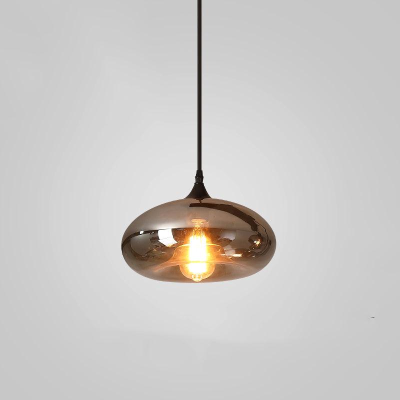 Clérachic hand-blown smoked glass pendant with a wide flattened disc shade, lit and hung on a black cord.