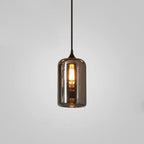 Tall cylinder Clérachic smoked glass pendant, its straight sides lit from within by a long filament bulb.