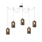 Five cylindrical Clérachic smoked glass pendants in a spider layout, each glowing with a vertical filament bulb.