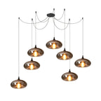 Seven flattened disc Clérachic smoked glass pendants spread from one spider canopy across a wide span.