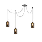 Three cylindrical Clérachic smoked glass pendants swagged from one canopy, each lit by an upright bulb.