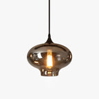 Studio close-up of a single onion-shaped Clérachic smoked glass pendant lit by a warm filament bulb.