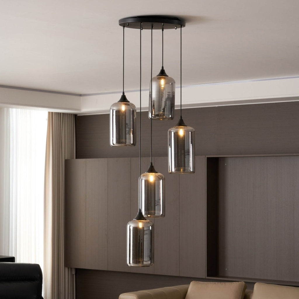 Five Clérachic smoked glass cylinder shades seen from below in a panelled lounge, cords at staggered drops.