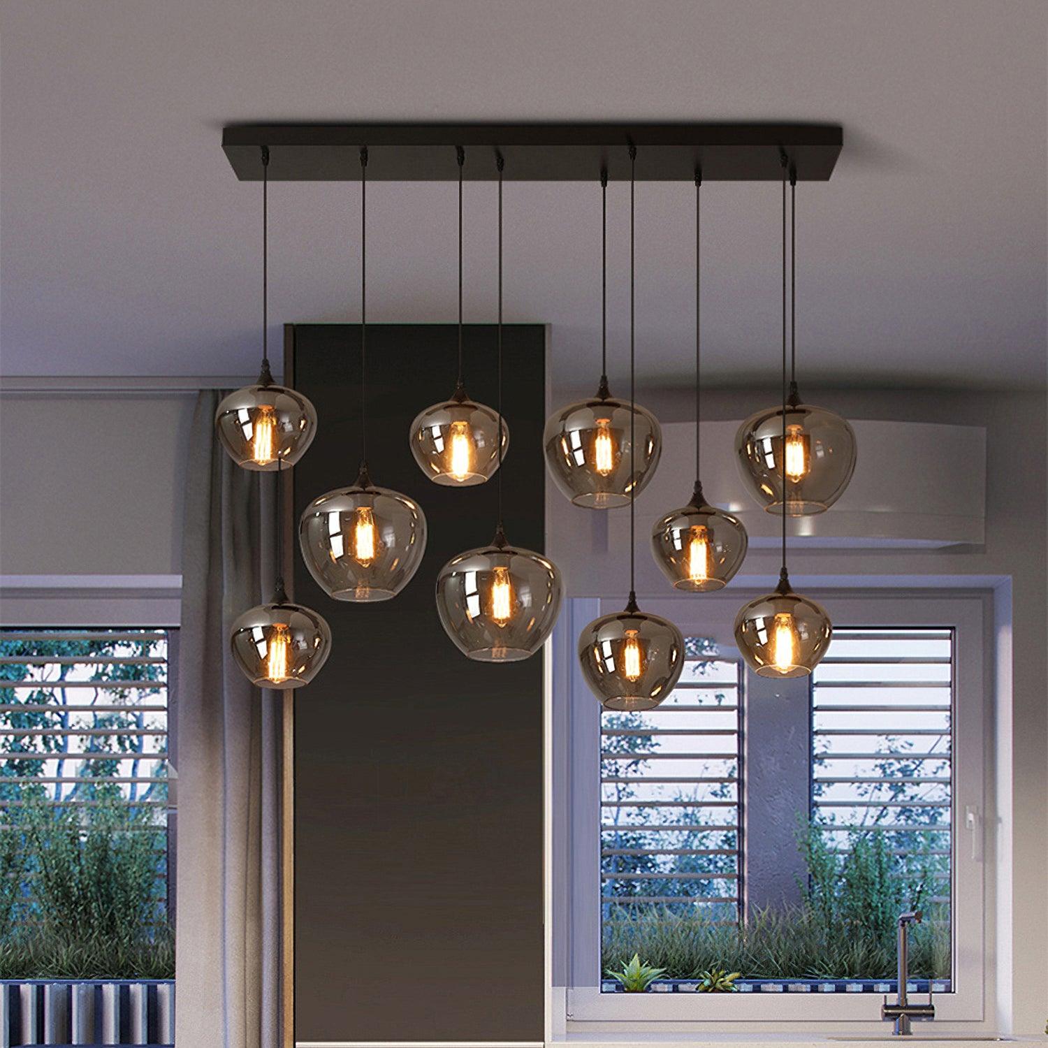Ten apple-bowl Clérachic smoked glass pendants on a black rectangular canopy above a kitchen window.
