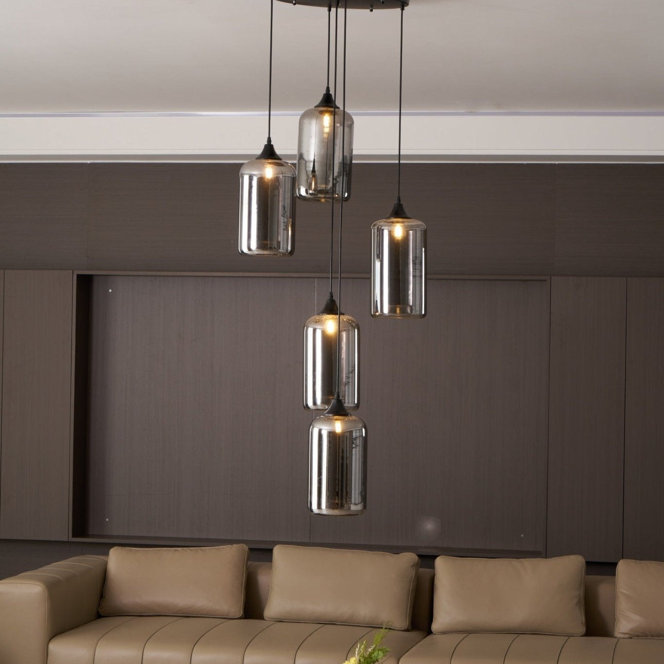 Five Clérachic smoked glass cylinders in front of a recessed timber panel, each lit by a warm bulb.