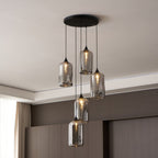 Close view of five lit Clérachic smoked glass cylinders, mirrored surfaces reflecting the room.
