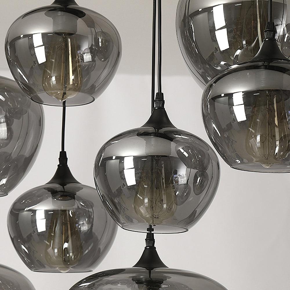 Close-up of clustered apple-bowl Clérachic smoked glass shades with their filament bulbs showing.