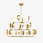 Three tiers of slim arms hold leaf-shaped shades round glowing globe bulbs on this brass-toned Clérachic chandelier, on a plain white backdrop.