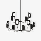 A black Clérachic chandelier on a white backdrop, two tiers of curved arms each carrying a leaf shade with a globe bulb.