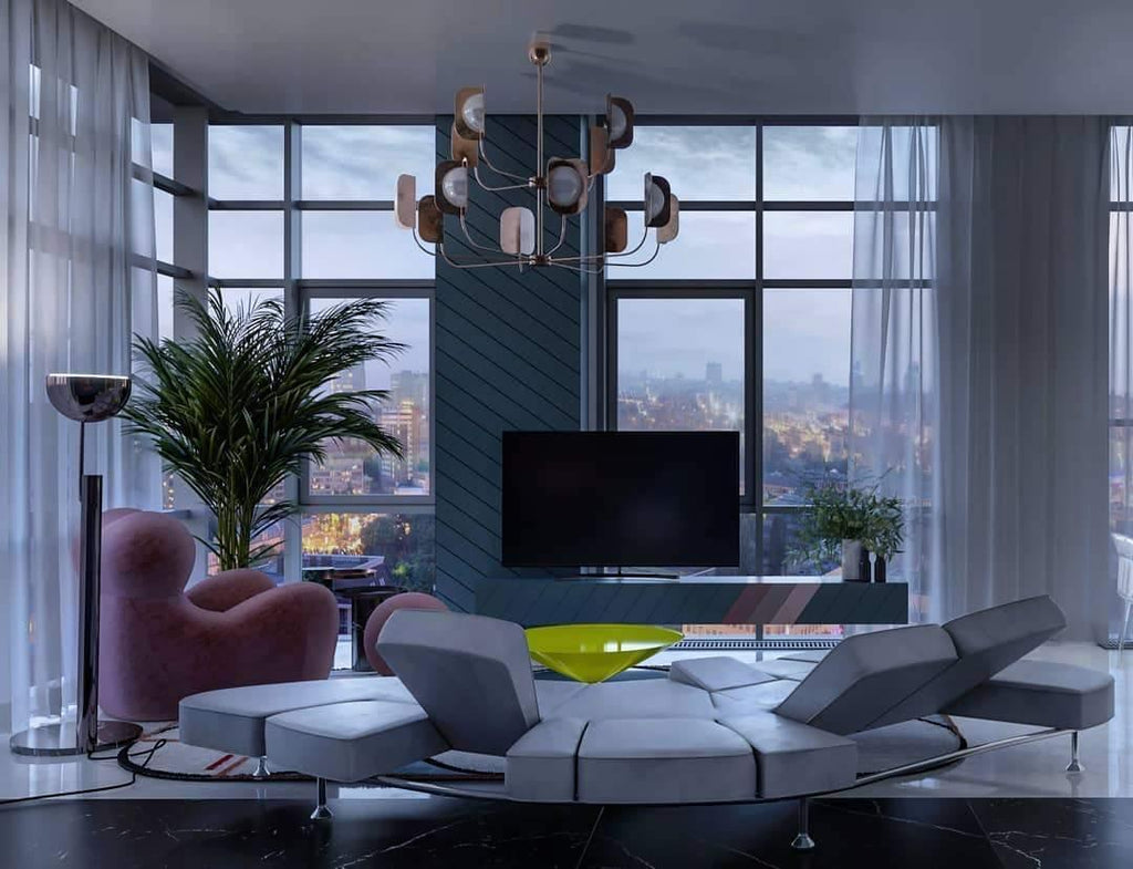 A Clérachic chandelier in a copper finish hangs above a curved grey sofa in a tower flat with floor-to-ceiling windows and a palm.