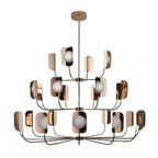 A copper Clérachic chandelier of three tiers with mirror-bright leaf shades and white globes, on a plain white backdrop.