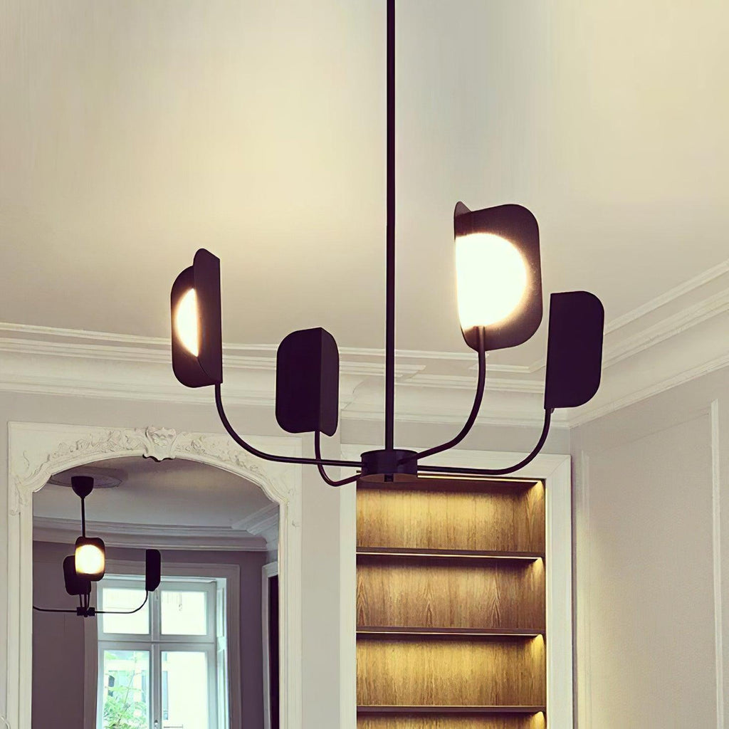 A black Clérachic chandelier on a rod, its leaf shades and a lit globe seen from below, with a plaster cornice and a glazed arch behind.