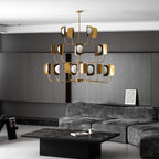 A large brass-toned Clérachic chandelier hangs above a low black coffee table in a dark panelled lounge with a grey sofa.