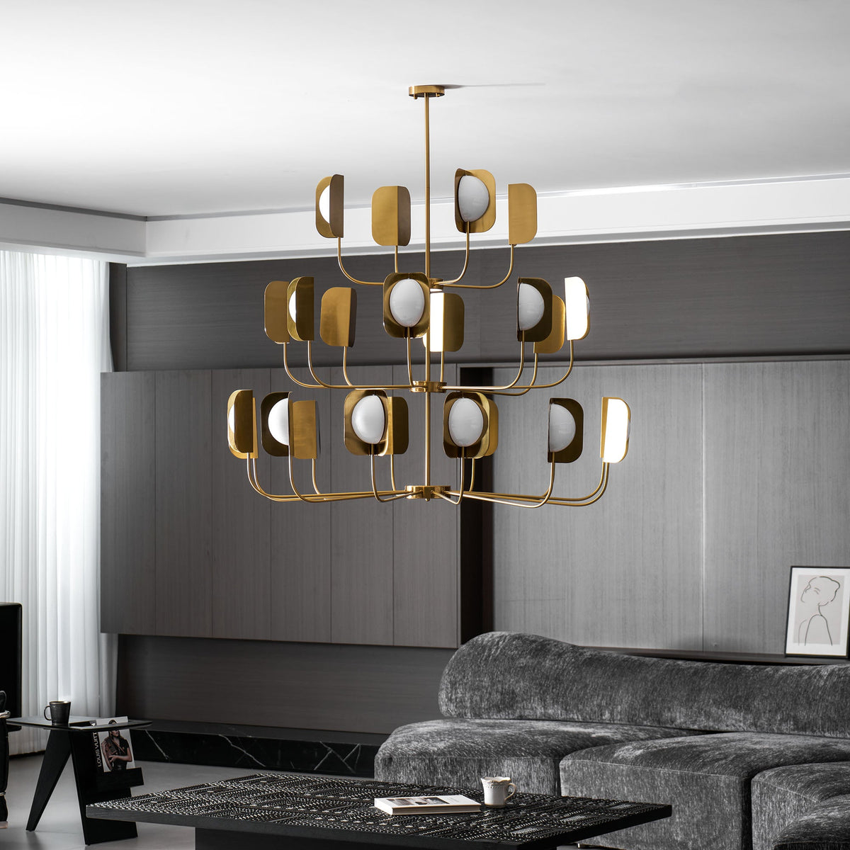 The same brass-toned Clérachic chandelier lit in the dark-panelled lounge, shown at a slightly lower angle with a curtain at left.