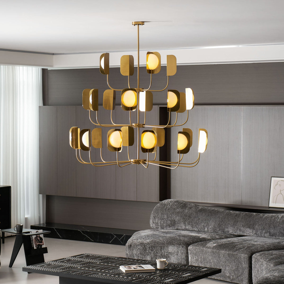 The brass-toned Clérachic chandelier lit in a dark-panelled lounge, with warm globes and leaf shades from the side.