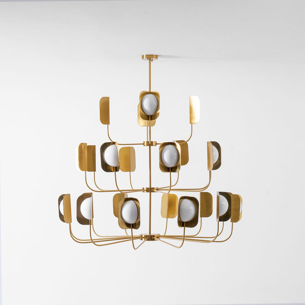 Front view of a brass-toned Clérachic chandelier with three evenly spaced tiers of leaf shades and globes, on a pale backdrop.
