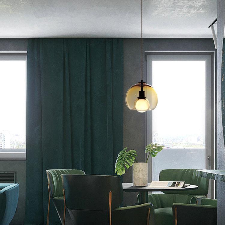 A cognac Clérachic pendant glows in a dark green dining corner with floor-length curtains and a small round table.