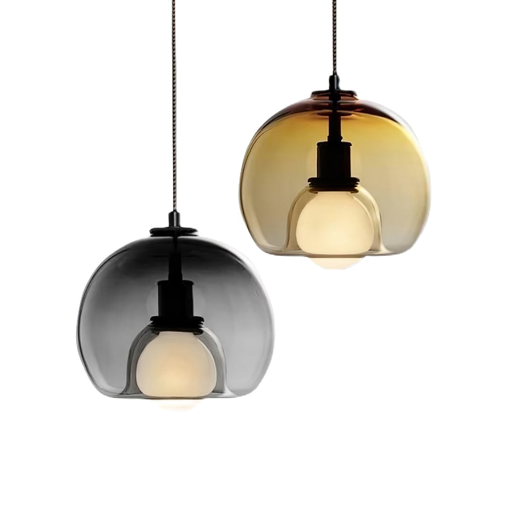 Two Clérachic pendants, one smoke and one cognac, shown close together on a white backdrop with frosted bulbs.