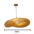 Clérachic woven bamboo pendant, 50 cm across, its twisted rattan shade lit from within.