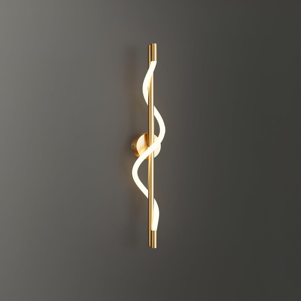 On a dark grey wall, a brass Clérachic wall light shows its glowing silicone spiral.