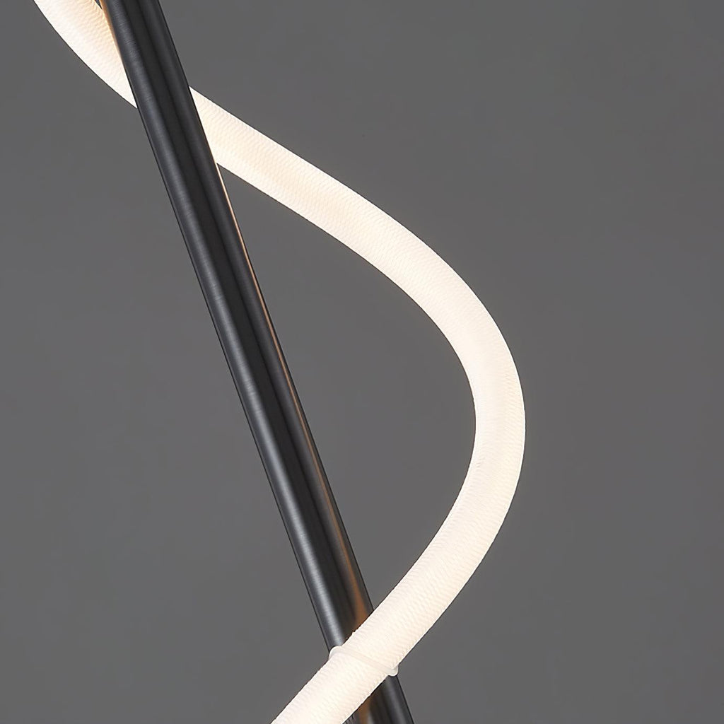 Close view of the white silicone band curving around the black rod of this Clérachic wall light on a grey backdrop.