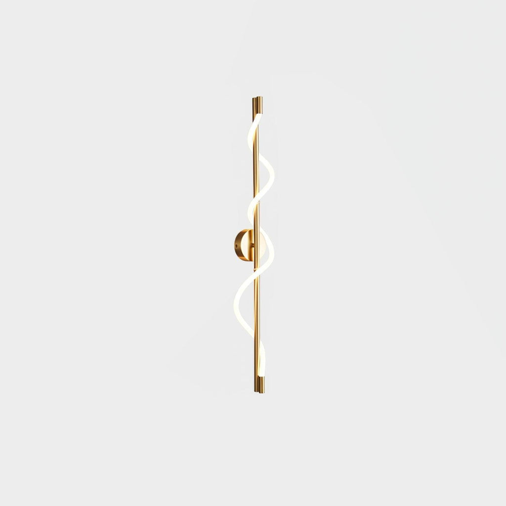 In brass, this Clérachic wall light shows a lit twisting band and a brass backplate, seen on a pale backdrop.