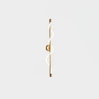 In brass, this Clérachic wall light shows a lit twisting band and a brass backplate, seen on a pale backdrop.