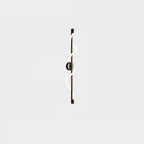 A small view of a black Clérachic wall light with a lit spiral band and a round backplate on a pale backdrop.