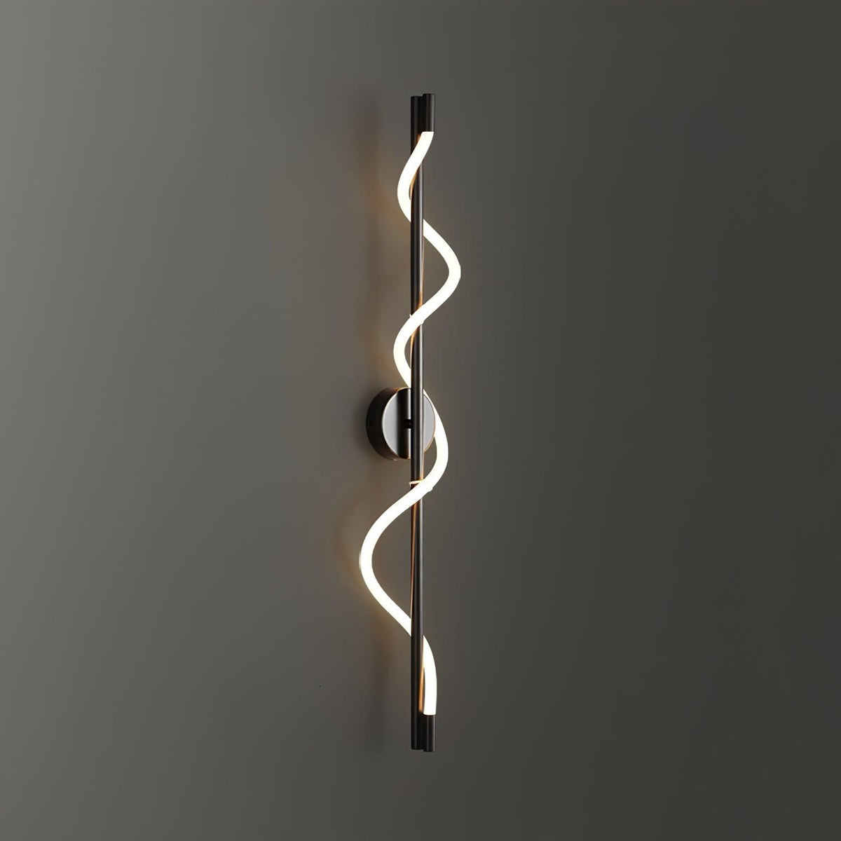 Against a dark grey wall, the bright two-turn spiral band of a black Clérachic wall light glows.