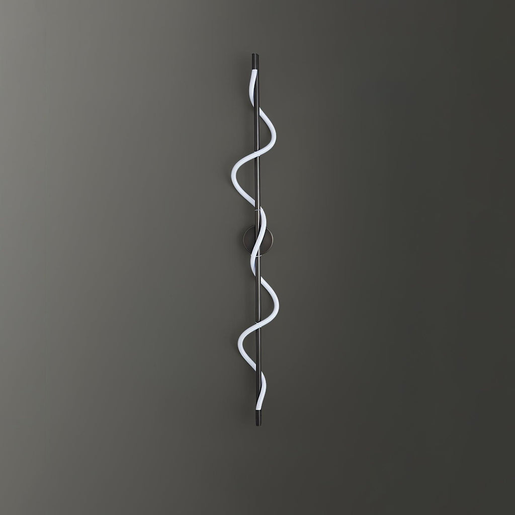 A black Clérachic wall light with a cool white spiral band on a dark grey wall, with the round backplate behind the rod.