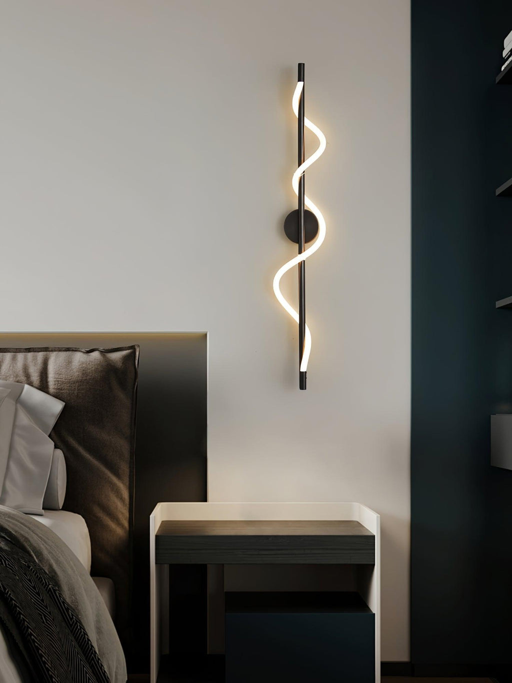 Over a dark bedside table, a black Clérachic wall light with a lit spiral band hangs by a deep blue panel.