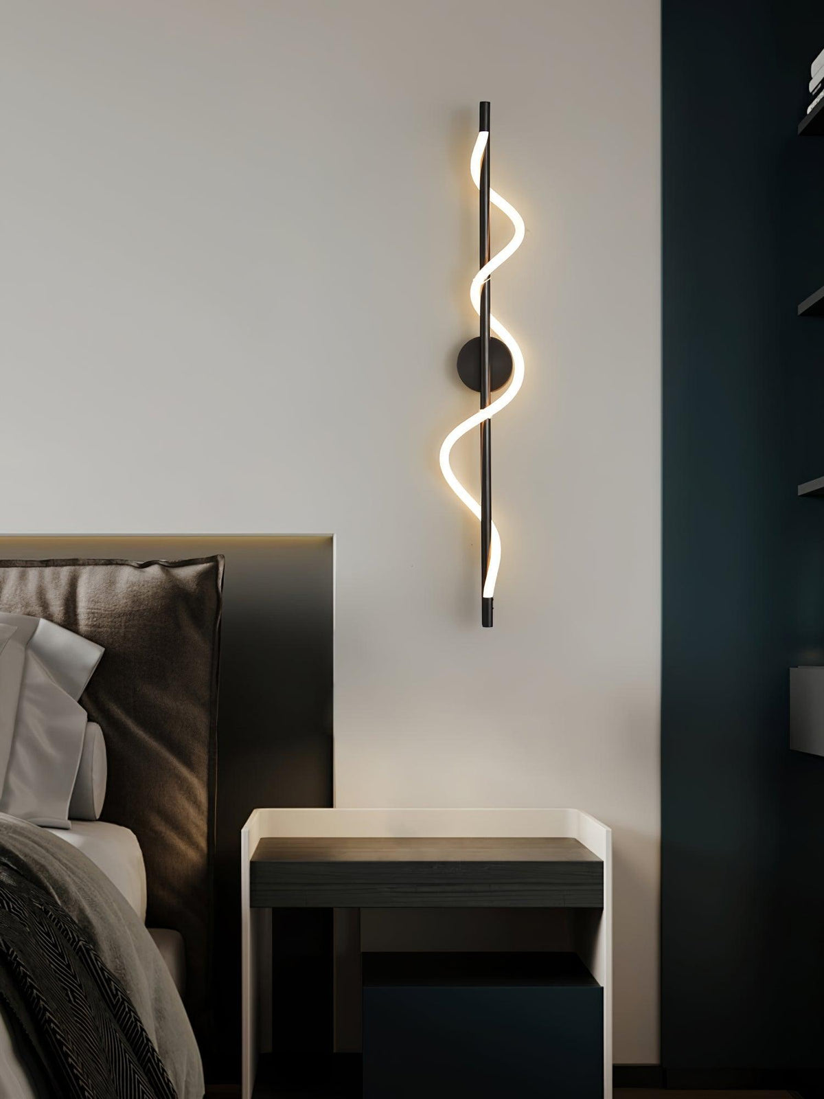 Over a dark bedside table, a black Clérachic wall light with a lit spiral band hangs by a deep blue panel.
