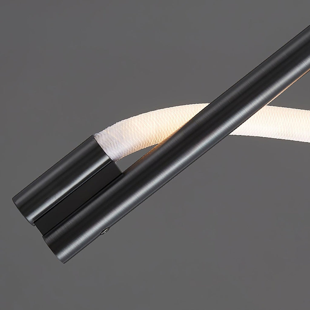 Close view of the black metal rod ends and the white silicone band curving past them on this Clérachic wall light.