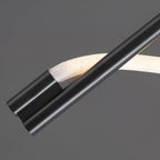 Close view of the black metal rod ends and the white silicone band curving past them on this Clérachic wall light.