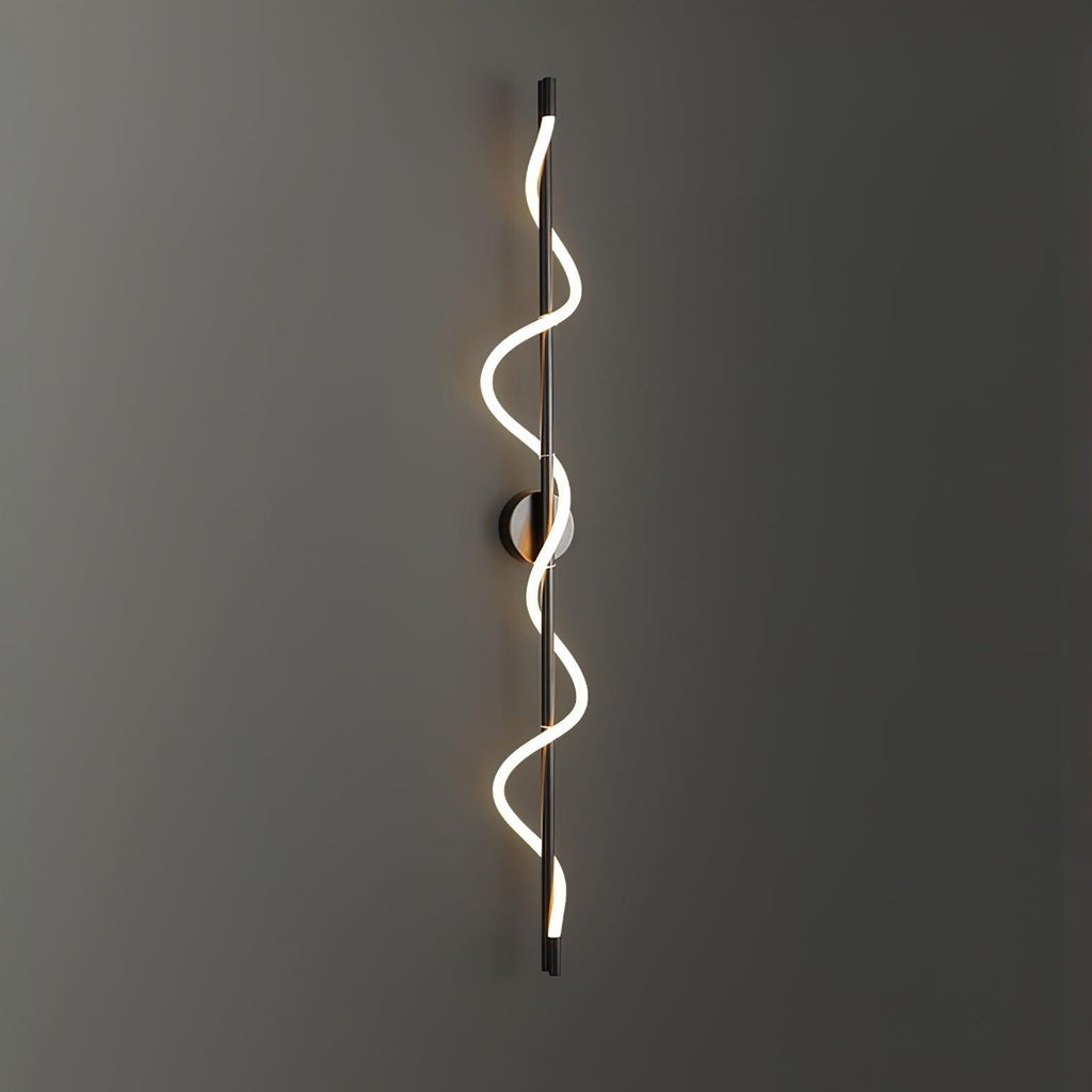 Glowing on a dark grey wall, a black Clérachic wall light with a two-turn spiral band and a round backplate.