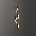 Mounted on a dark grey wall, a black Clérachic wall light with a lit spiral band wrapping its rod.