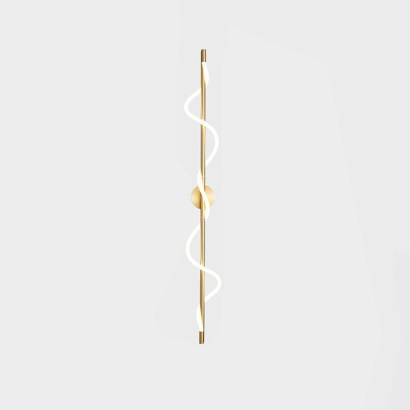 A tall brass Clérachic wall light with a lit two-turn spiral and a round backplate on a pale backdrop.