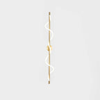 A tall brass Clérachic wall light with a lit two-turn spiral and a round backplate on a pale backdrop.