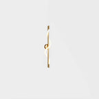 A small brass Clérachic wall light with a lit spiral band and a round backplate, on a plain pale backdrop.